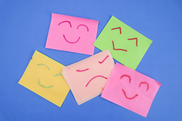 在蓝色背景上用红色和绿色标记画出5个表情的便利贴。图片下载