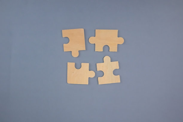 灰色背景上的4个木制拼图。图片下载