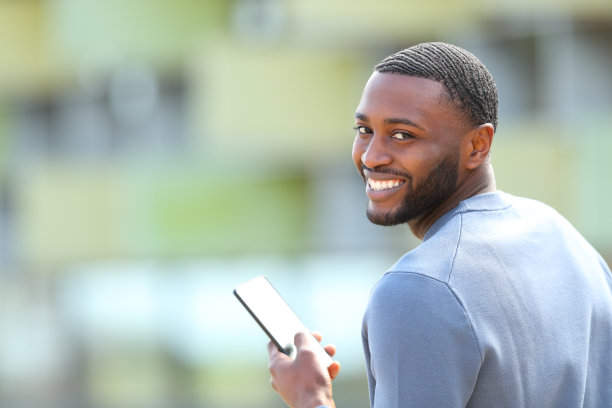 快乐的黑人拿着手机看着相机图片下载