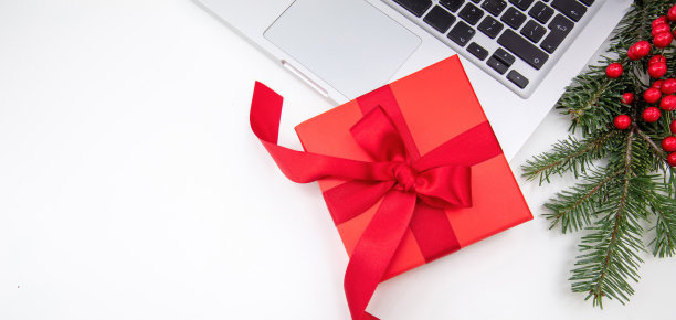 圣诞假期。红色礼盒，笔记本电脑和白色的圣诞装饰图片下载