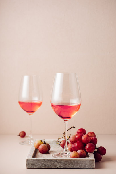 两杯玫瑰酒和红葡萄。图片下载