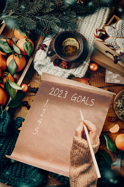 一位女士在一张圣诞装饰的手工纸上写字，俯视图。新年目标。高画质照片图片下载