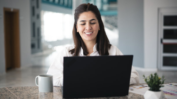 商务女性在办公室用笔记本电脑工作图片下载