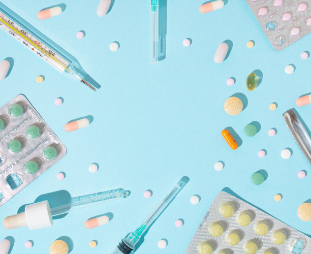 创意医学的概念在蓝色背景上，药物，药丸，移液管，注射，塑料医用注射器，临床温度计。现代制药看与复制空间。前视图。图片下载
