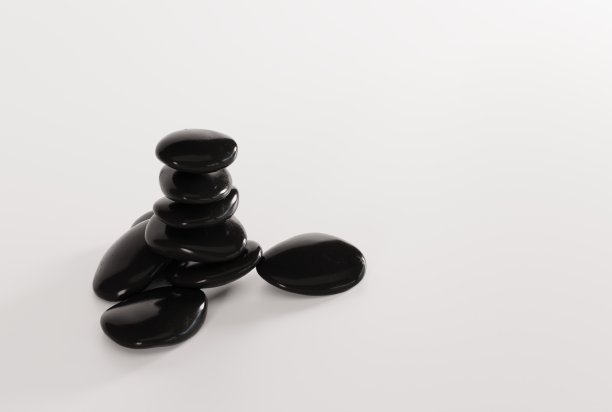 黑色按摩石在光的背景。图片下载