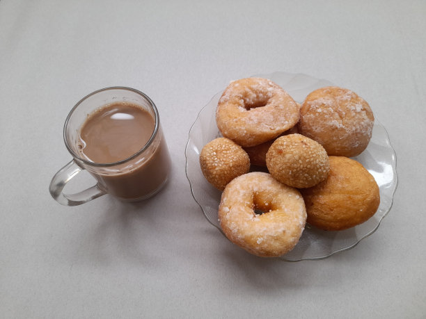 咖啡牛奶杯和糕点食品组成的甜甜圈，onde onde，枕头蛋糕在一个白色背景的盘子。图片下载