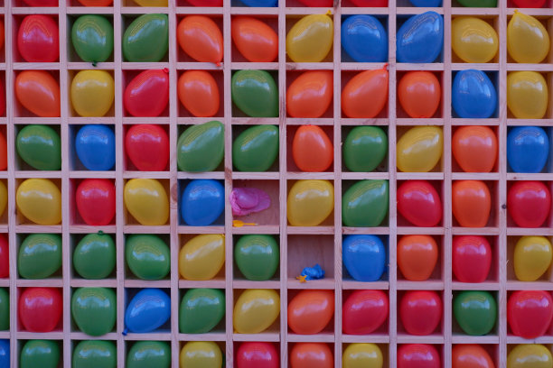 空气飞镖。牢房里用来玩飞镖的彩色充气球。玩飞镖用的彩色气球。彩色背景，彩虹色。图片下载