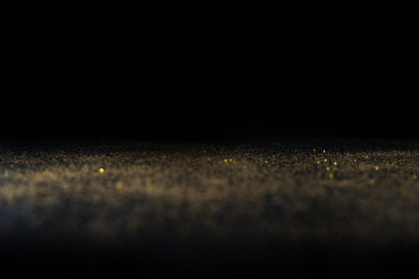 深色的质地中有金色的点缀。背景与金色闪光覆盖照片效果滤镜。花哨，豪华，主题背景。图片下载