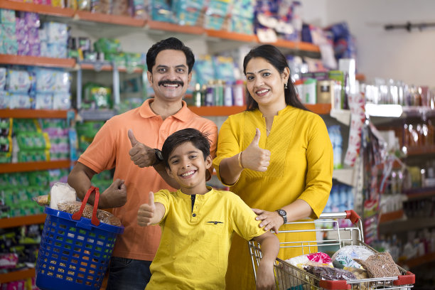 一家人拿着杂货在商店里竖起大拇指图片下载