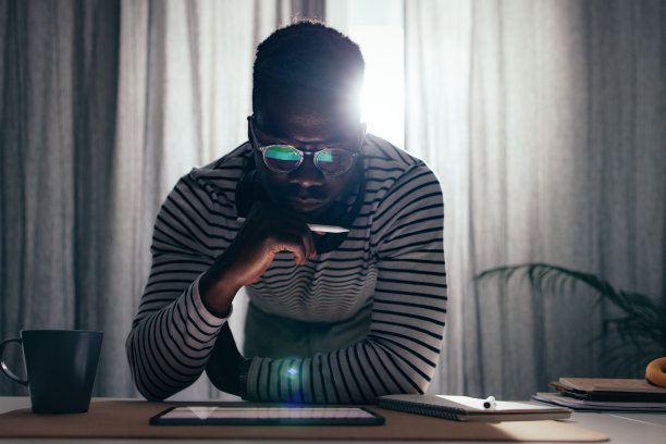 Serious BusinessmanÂ Working At Home On A Digital Tablet图片下载
