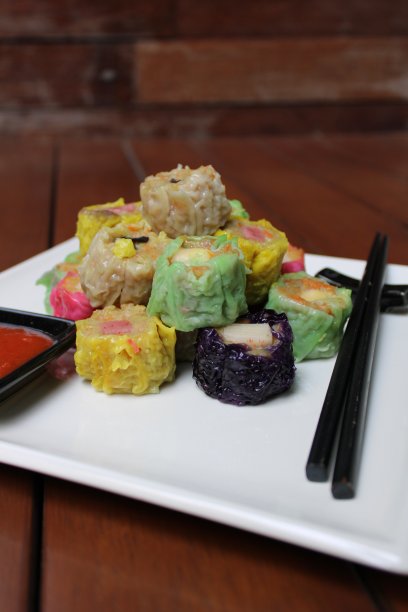 彩色点心放在木质背景的白色盘子里图片下载