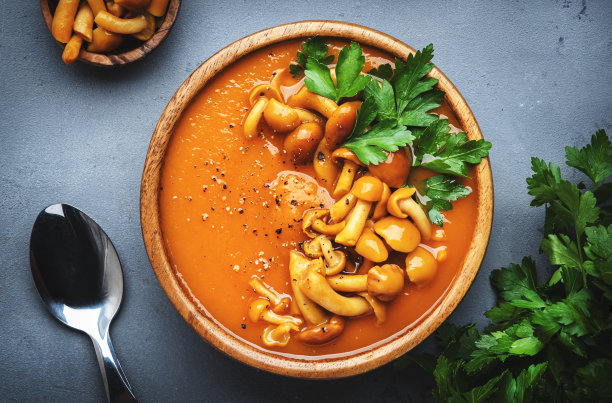 辣南瓜胡萝卜汤泥，蘑菇，胡椒和欧芹。冬秋健康纯素素食。汤碗在灰色的桌子背景。俯视图图片下载