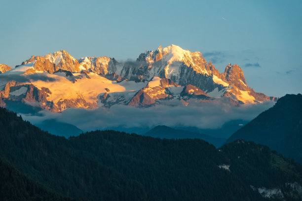 日落时美丽的山景，将岩石和雪变成橙色图片下载