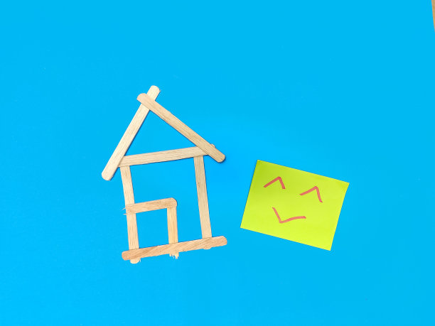 一幅用冰淇淋棒做成的房子的插图，上面有一张绿色的笑脸便利贴。图片下载