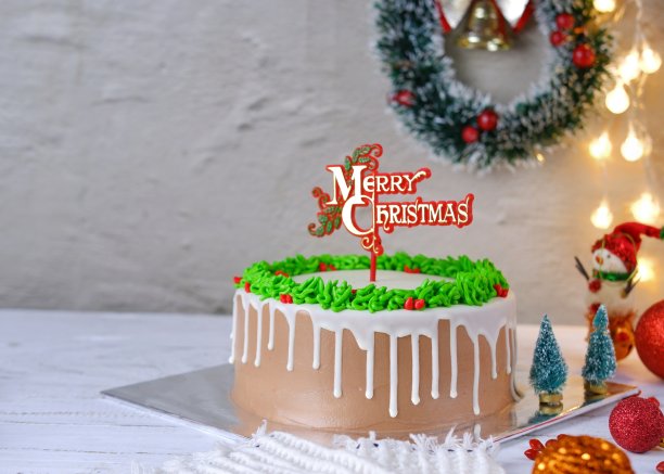 圣诞蛋糕放在桌子上，白色的背景和圣诞装饰图片下载