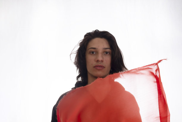 年轻男子与红色透明面料在白色背景的运动。图片下载