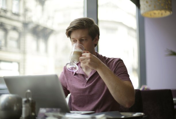 男性一边喝咖啡一边用笔记本电脑图片下载