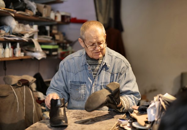 一个修鞋的老男人的选择性聚焦镜头图片下载