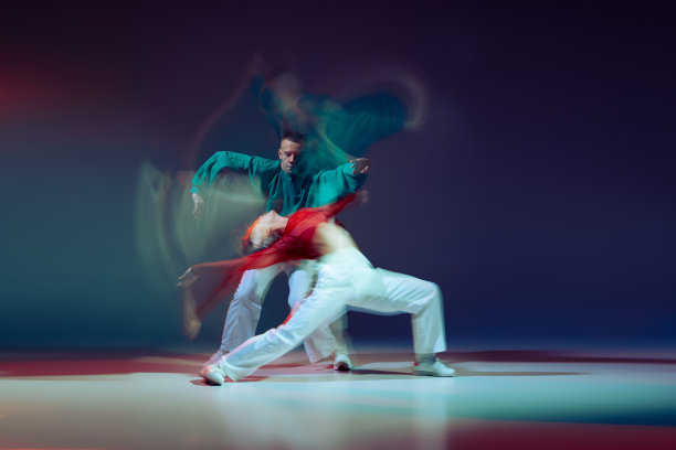 年轻的男人和女人跳街舞的肖像，在深蓝色的背景和混合的灯光上分离的沉思。创造力图片下载