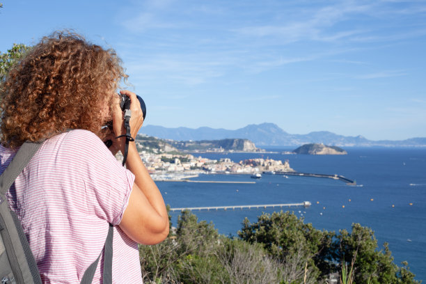 意大利，一名女子在海湾拍照图片下载