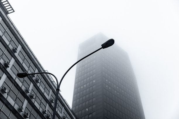 低角度俯瞰空气污染城市的摩天大楼图片下载