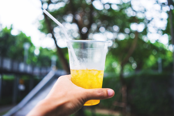 人类的手举起了冰饮料，对着城市的天际线-图片图片下载