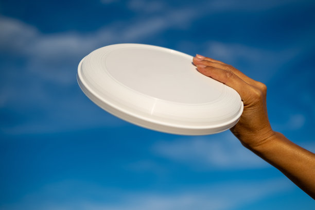 女性手里拿着白色飞盘。图片下载