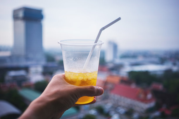 人类的手举起了冰饮料，对着城市的天际线-图片图片下载