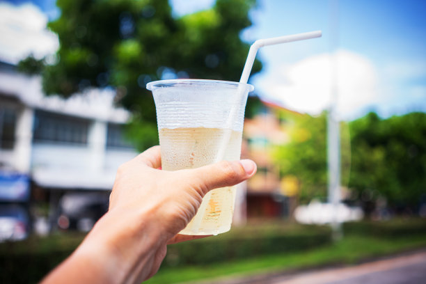 人类的手举起了冰饮料，对着城市的天际线-图片图片下载