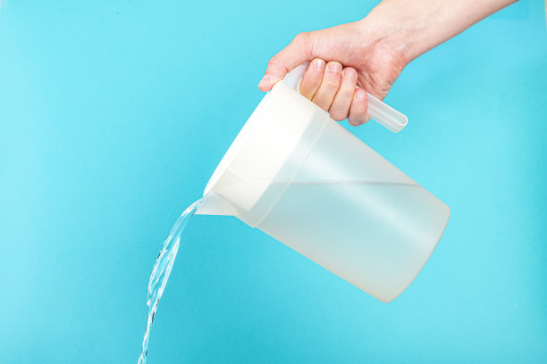 从蓝色背景下的塑料罐中倒水图片下载