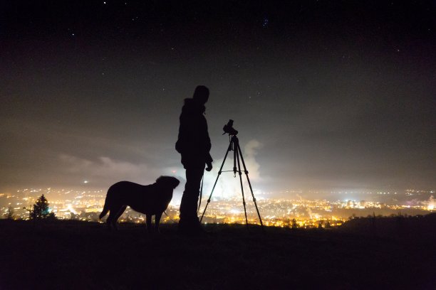一个人的剪影，一只狗和一个相机在晚上图片下载