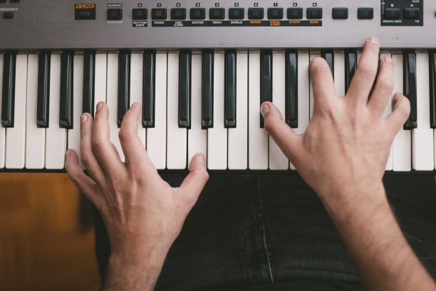 钢琴家演奏电子钢琴键盘的高角度视图图片下载