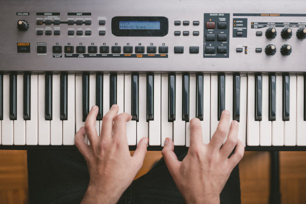 钢琴家演奏电子钢琴键盘的高角度视图图片下载