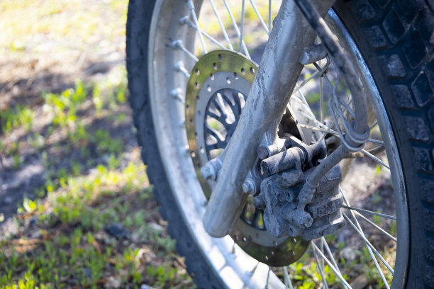 停在草地上的摩托车前轮的特写。图片下载