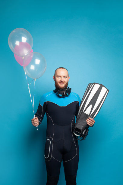 穿着潜水服，带着气球的帅哥。庆祝和节日的概念图片下载