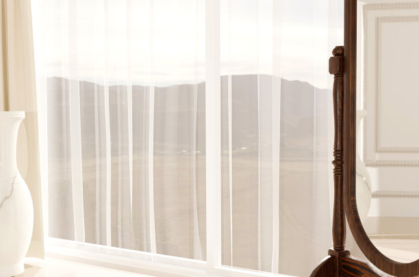 室内有垂直窗户，窗帘可以俯瞰草地，装饰性陶瓷和垂直镜子。图片下载