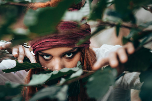 身着海盗服装的年轻女子从树枝上爬过图片下载