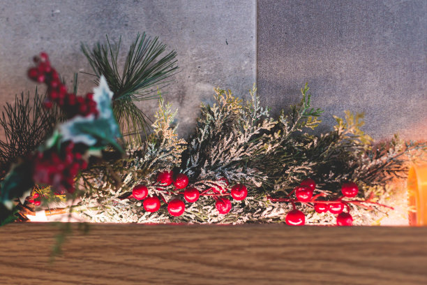 在现代室内的新年圣诞装饰元素，咖啡馆，餐厅，商店或酒店新年发光的装饰，红色的浆果，树枝和玩具，彩花和花环和花环图片下载