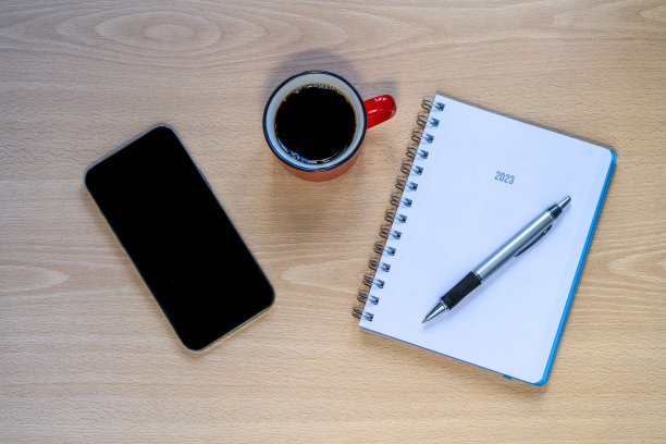 手机，咖啡杯和记事本放在木桌上图片下载