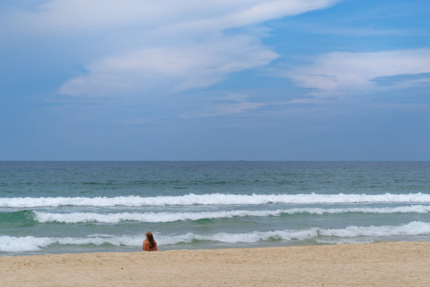 远处的女子在田园诗般的海滩上放松图片下载