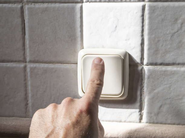 一只白种人的手在开灯。图片下载