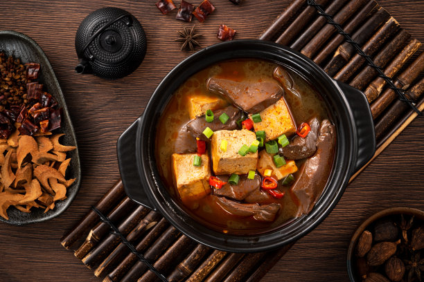 辣味鸭血冻汤和臭豆腐，上面有葱和辣椒。图片下载