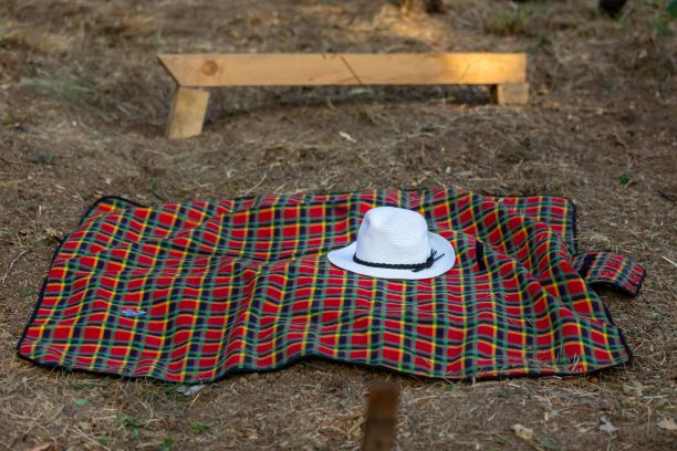 森林里野营毯子上的白色草帽图片下载