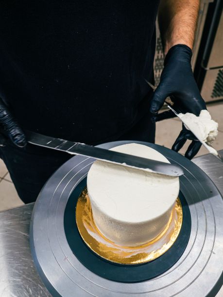 厨师用抹刀和器具将奶油磨砂蛋糕抹平图片下载
