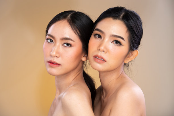 肖像脸拍摄了两个美丽的年轻亚洲女性与时尚化妆品化妆干净的皮肤在黄色米色背景隔离。Vintage Fashion化妆护肤一起，复制空间图片下载