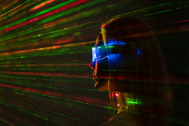 在激光射线背景下，戴着现代护目镜的女人图片下载