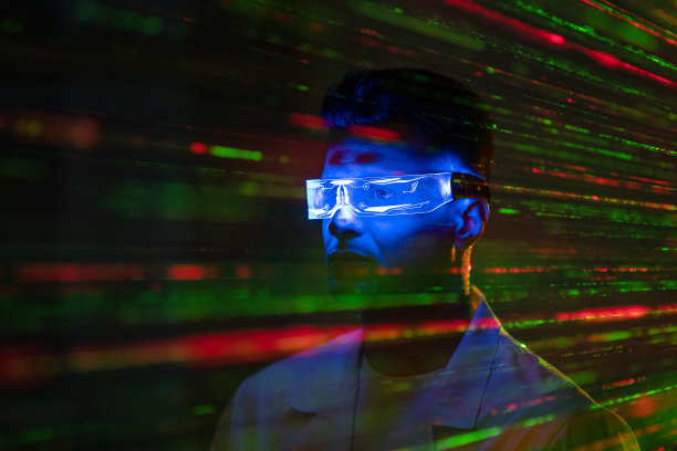 戴着未来主义眼镜的年轻人站在激光束的背景上图片下载