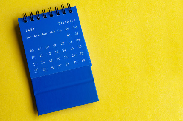2023年12月蓝色台历，黄色封面背景，可定制空间的文字。日历概念和复制空间。图片下载