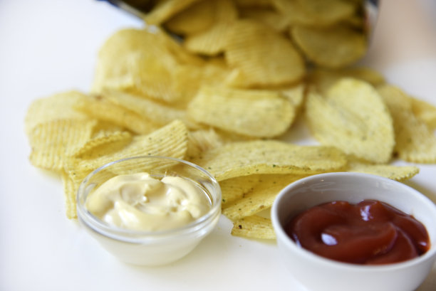 白色底色的黄色带槽薯片。美味的快餐炸土豆。图片下载