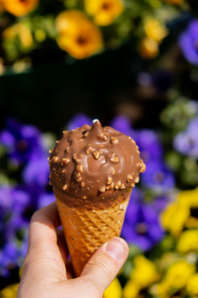 女性手拿美味的美国香草巧克力冰淇淋。美味的自制冰淇淋夹在华夫蛋筒里。无麸质素食乳制品图片下载